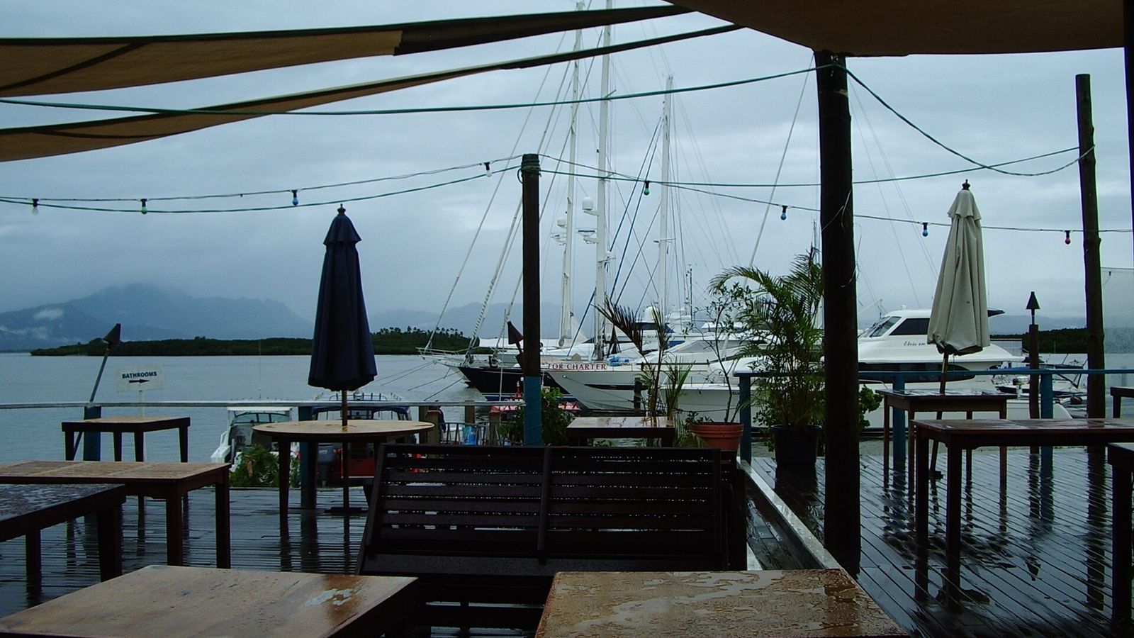 Overdekt terras van een restaurant aan de jachthaven van Port Denarau met zeilboten
