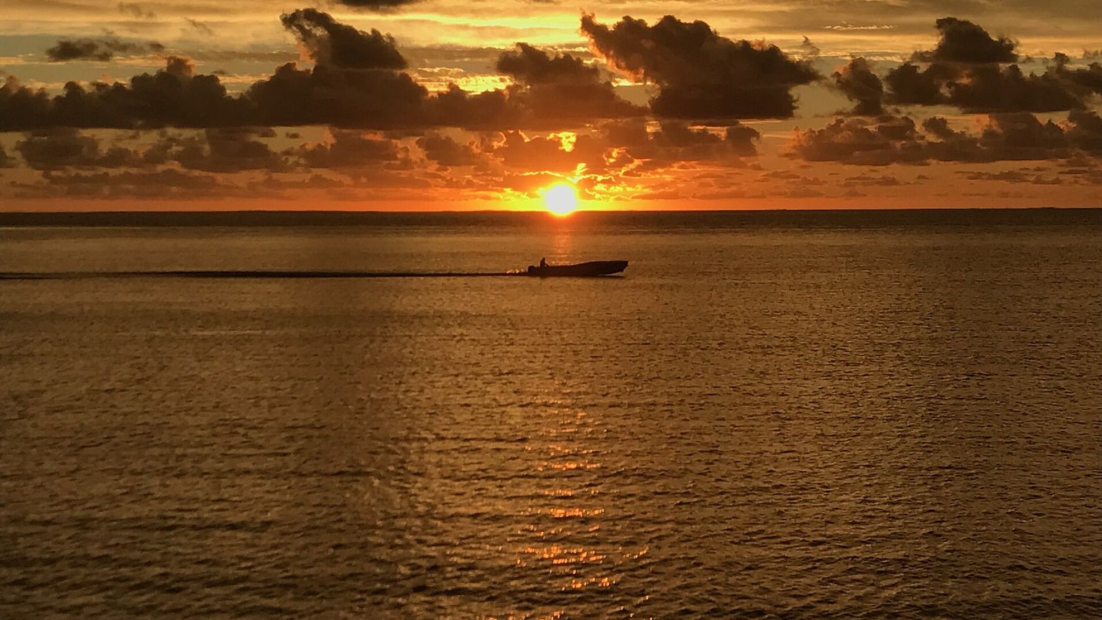 Zonsondergang boven de lagune bij Likuliku met een bootje op het water