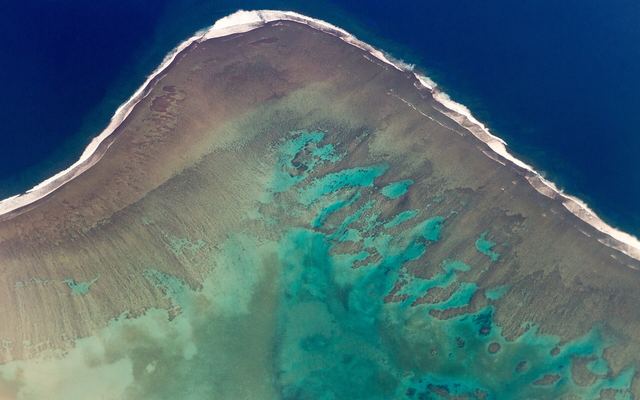 Luchtfoto van het Malolo-barrièrerif met turquoise lagune en branding