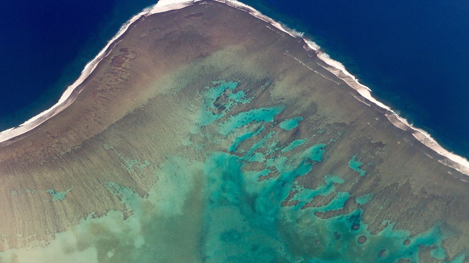Luchtfoto van het Malolo-barrièrerif met turquoise lagune en branding