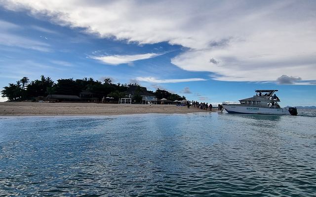 Beachcomber Island met strand, palmen en een aangemeerde boot in de Mamanuca-eilanden