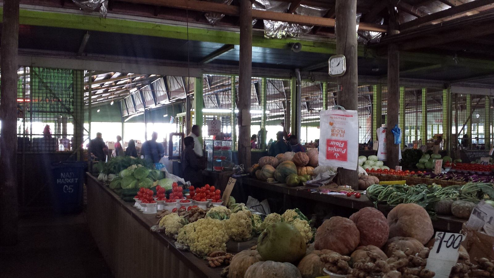 Kramen met pompoenen, groenten en fruit in de overdekte markthal van Nadi