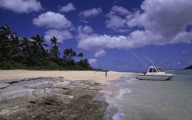 Strand met een motorboot aan de kust van Taveuni