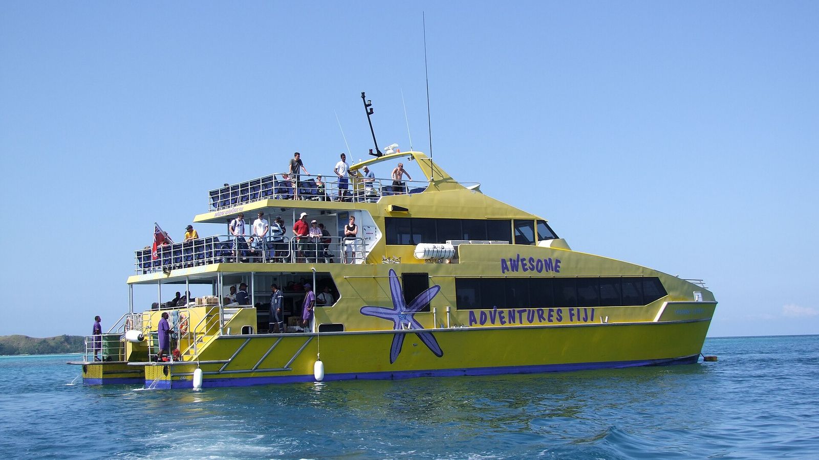 De gele Yasawa Flyer-catamaran van Awesome Adventures op zee